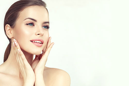 Woman touching her face smiling about her results from Always Beautiful.