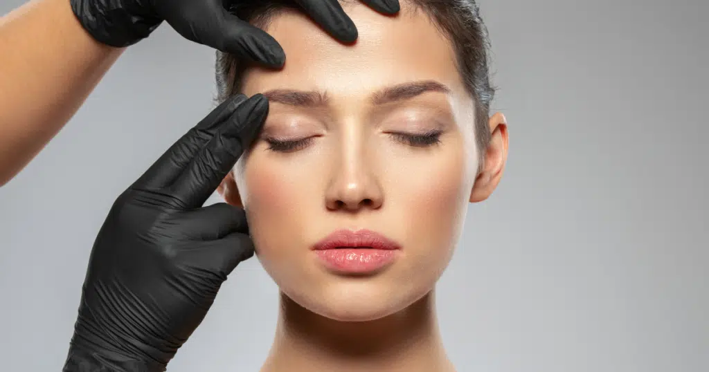 a gorgeous lady's face closes her eyes while someone holds her eyelid